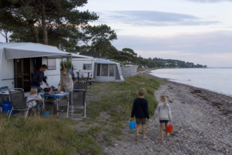 Familie bereitet das Abendessen auf einem Campingplatz bei Eckernförde vor [Bildinhalt mit KI erstellt]