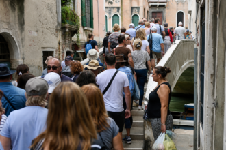 Dichtes Gedränge von Reisegruppen auf einer schmalen Brücke in Venedig [Bildinhalt mit KI erstellt]